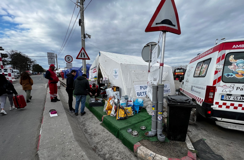 People approaching an ambulance and tent with supplies in Ukraine
